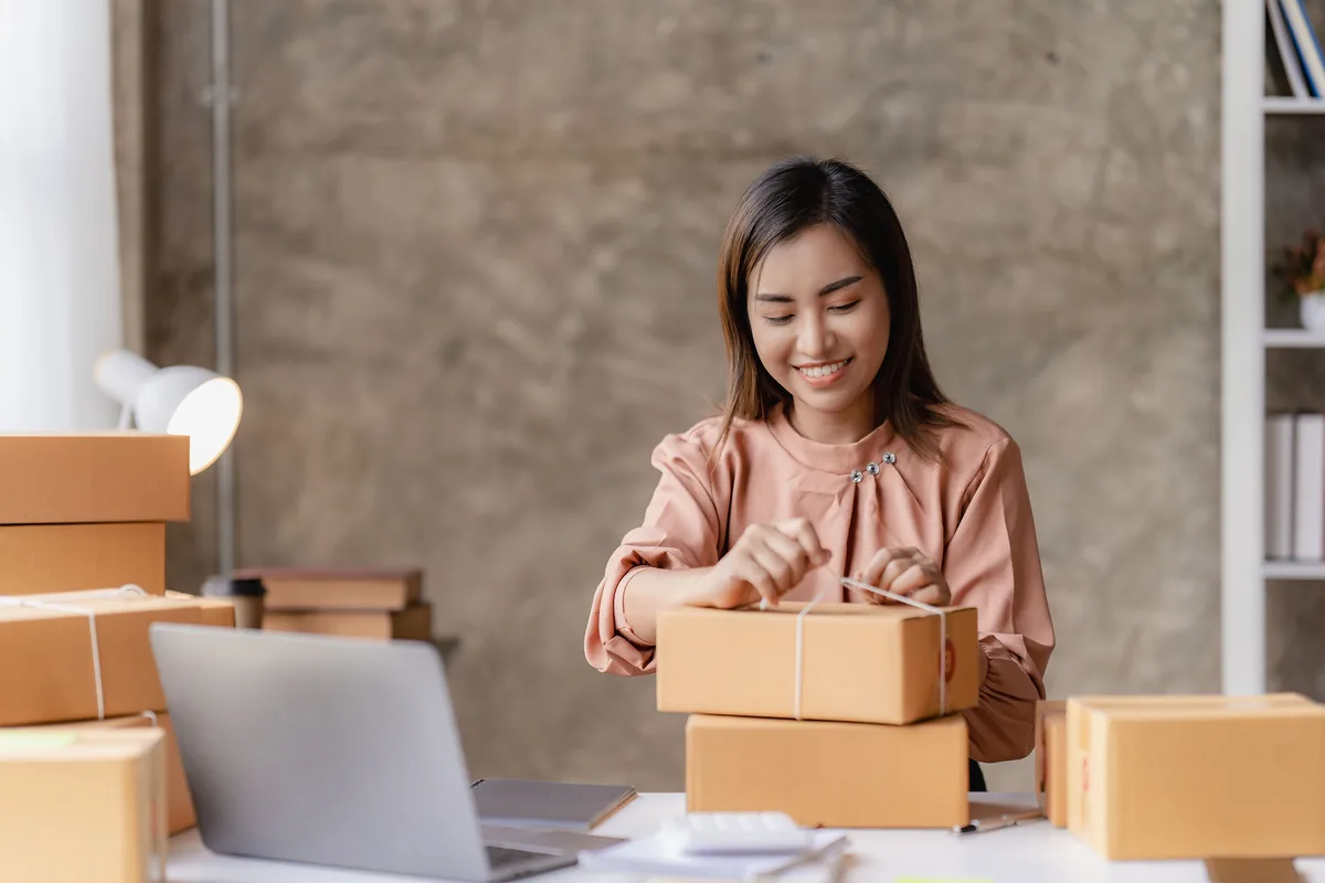 An online seller packing orders into boxes at a table